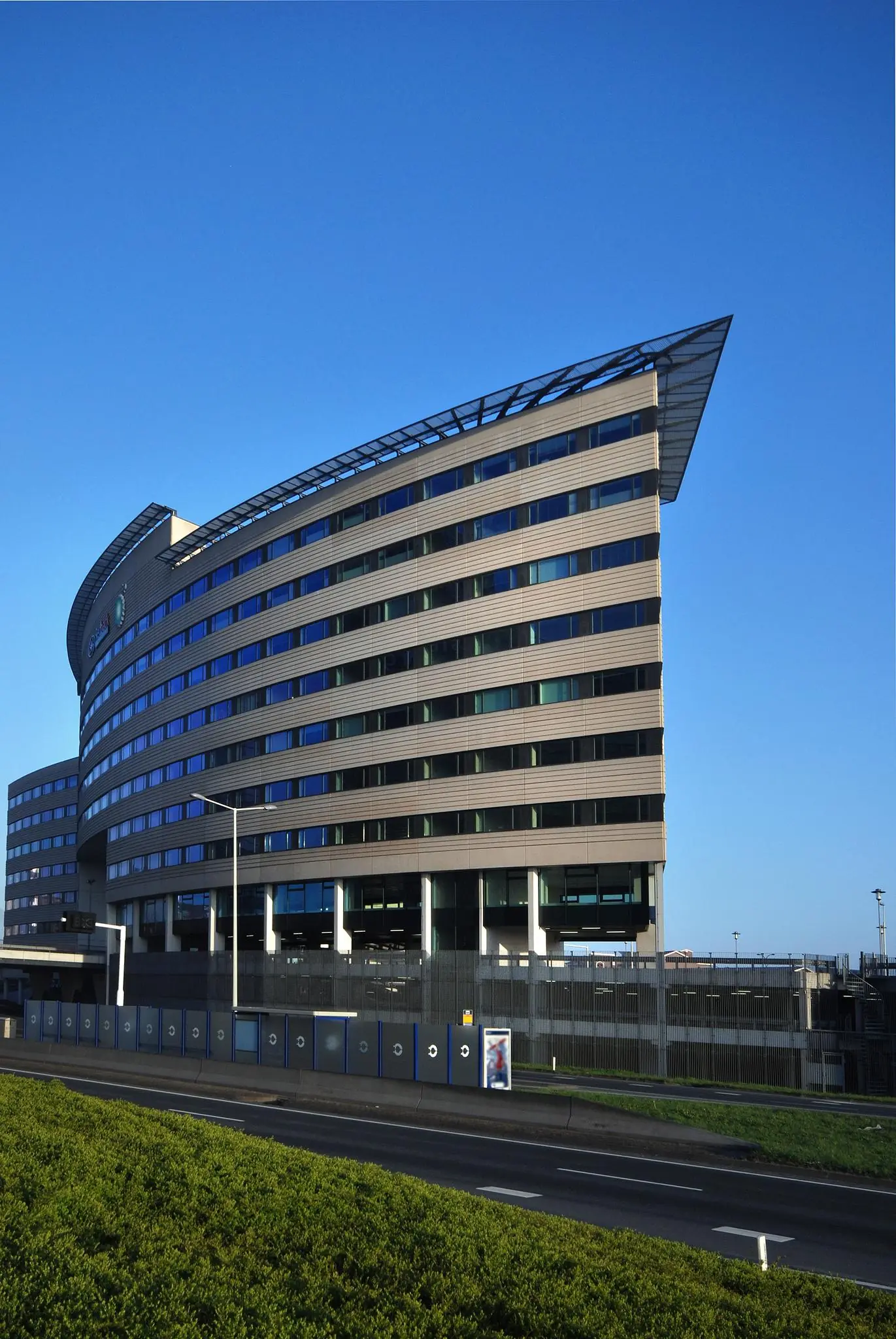Modern kantoorgebouw aan de Rivium Boulevard met gebogen gevel en opvallend puntdak.